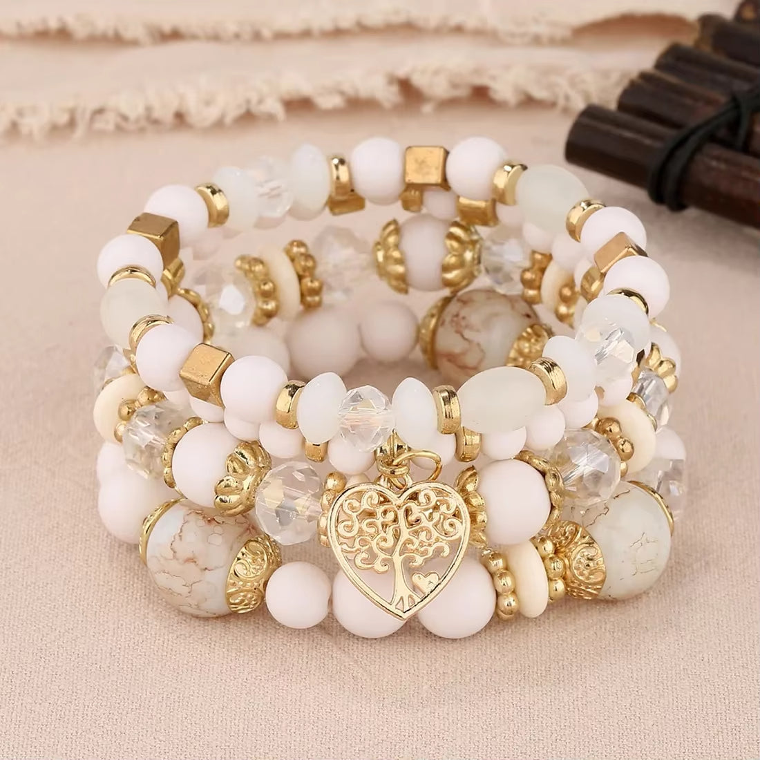 Ensemble de 4 Bracelets Arbre de Vie Blancs avec Perles sur fond beige