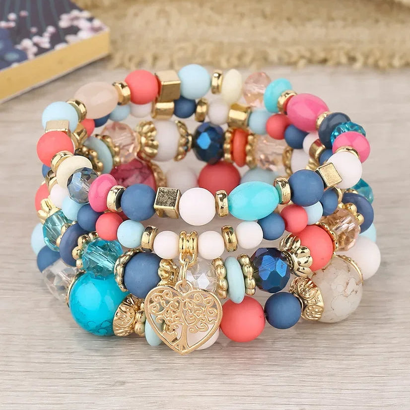 Ensemble de 4 Bracelets Arbre de Vie Multicolores avec Perles sur fond beige