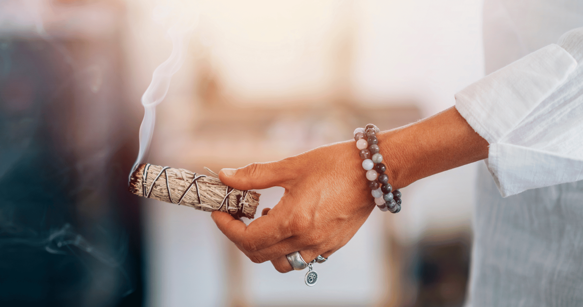 Zoom sur une main qui tient de la sauge fumante en train de faire un nettoyage energetique Image