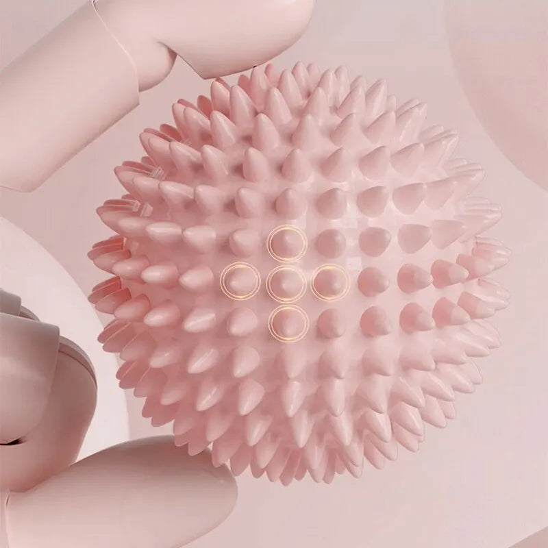 Boule de massage rose à libération myofasciale avec pointes sur fond rose