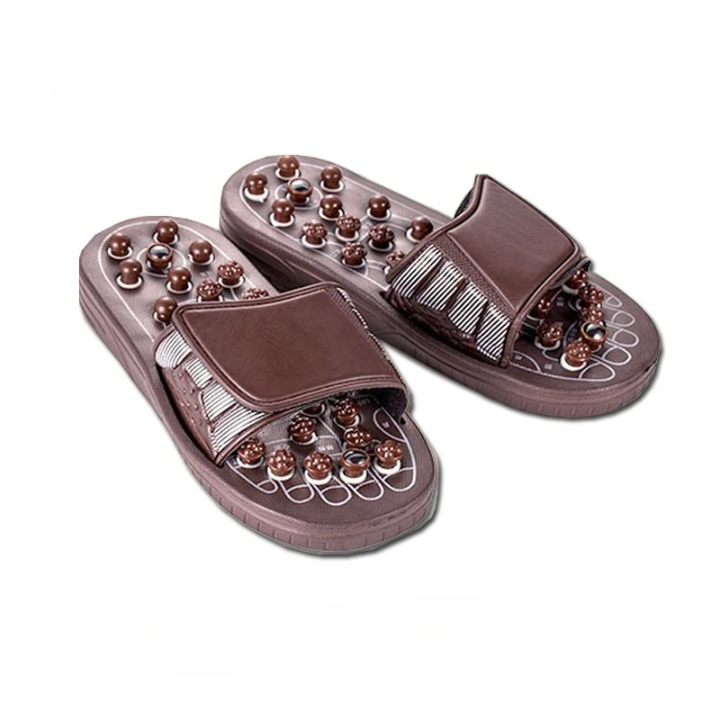 Pantoufles d'acupression marrons et massantes sur fond blanc