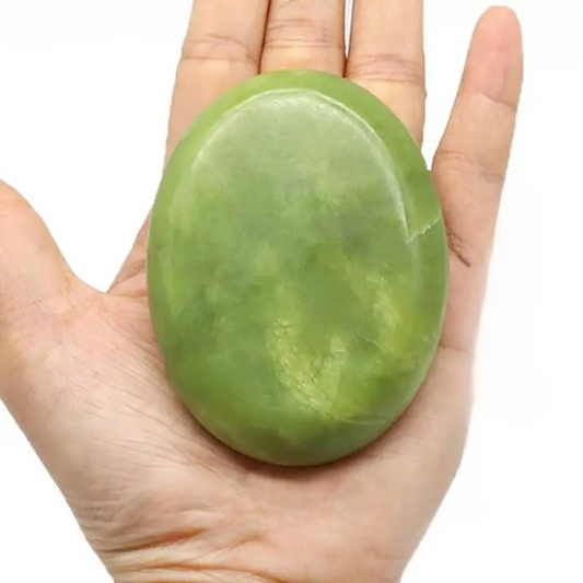 Pierre de jade unitaire pour relaxation dans une main sur fond blanc