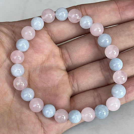 Bracelet en perles de béryl et quartz rose dans la main d'une personne