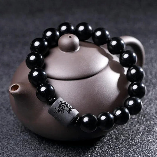Bracelet en perles de tourmaline de style ethnique sur une théière sur fond gris