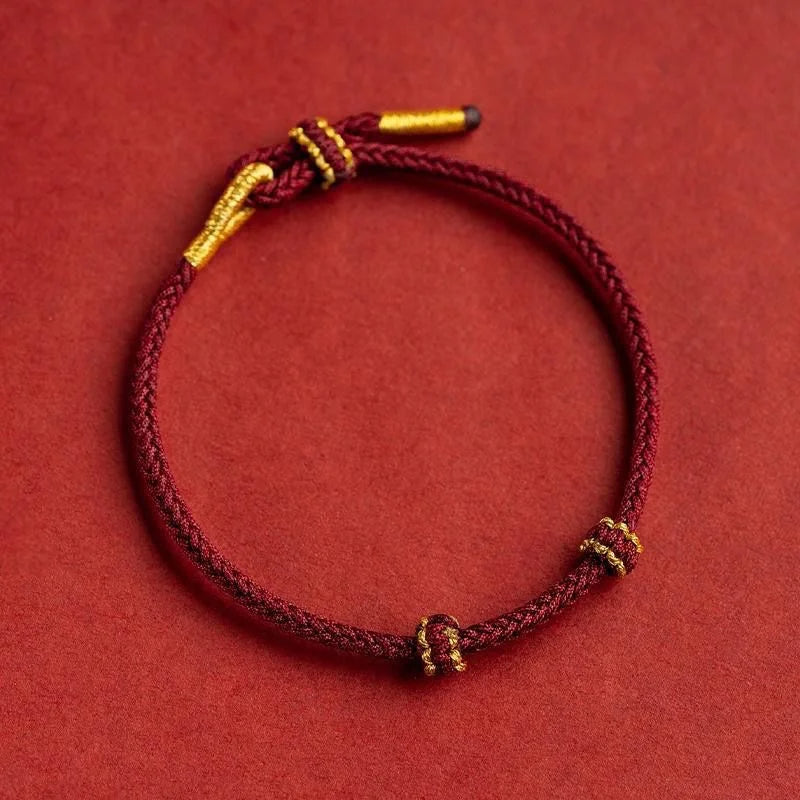 Bracelet rouge et doré en coton sur fond rouge