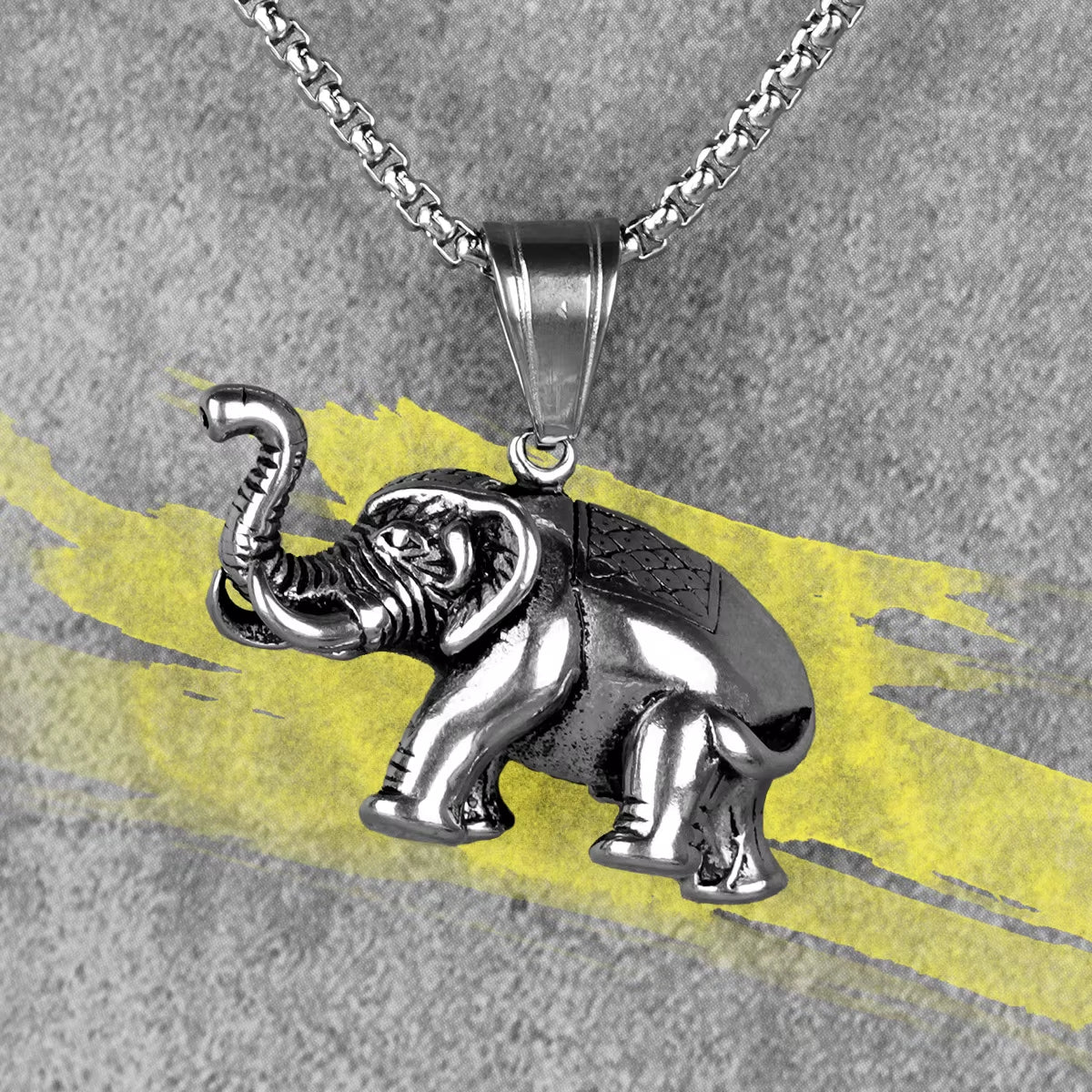 Pendentif Elephant en Acier Inoxydable sur fond gris et jaune