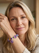 Femme souriante portant le bracelet en amethyste naturelle, modele Le Temple Yogi