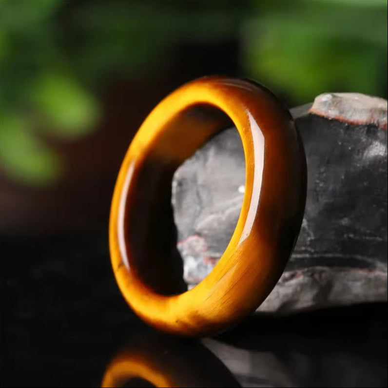 Bague Pierre Naturelle - Oeil de Tigre contre une pierre Image