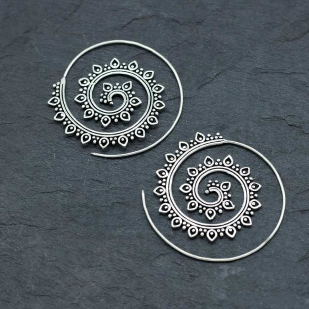 Boucles d'oreilles spirale argentées, gros plan sur les spires