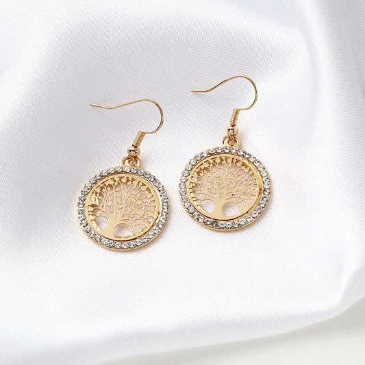Boucles d'oreilles dorées avec arbre de vie sur fond blanc