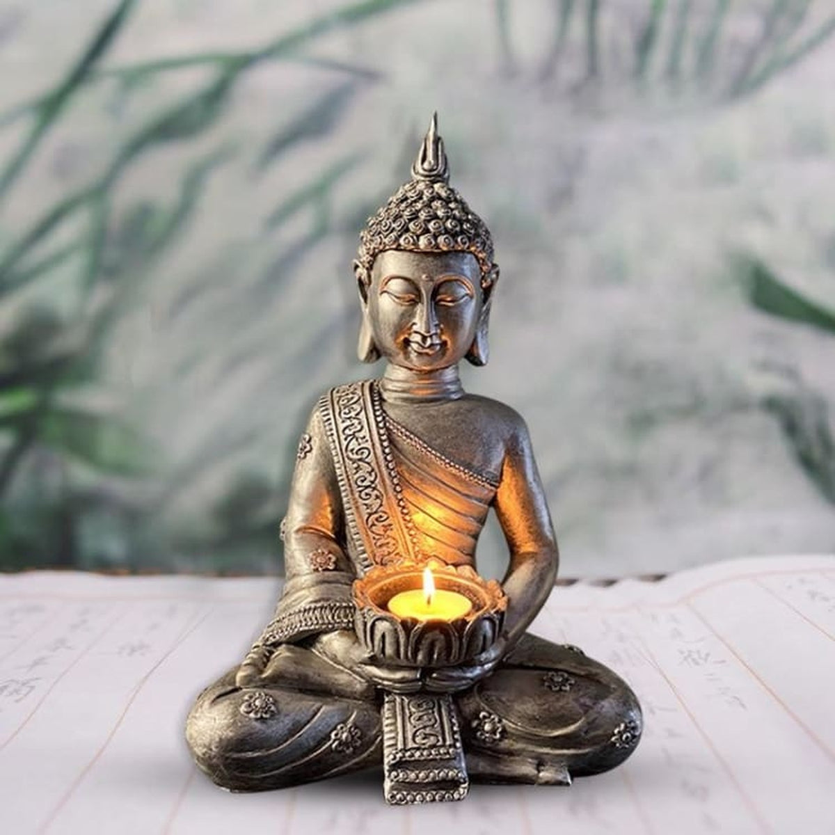 Bougeoir Bouddha mains réunies posé devant un décor végétal