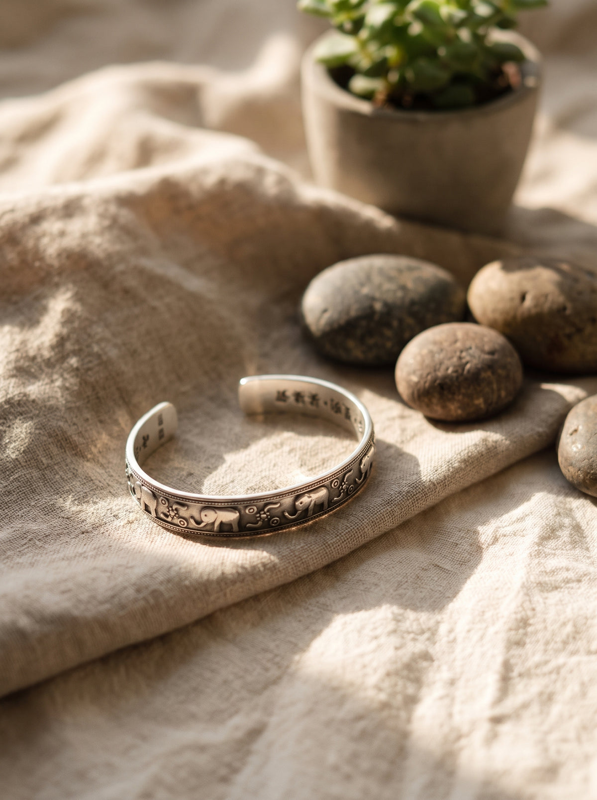 Bracelet manchette en argent sterling 925 pose sur lin naturel avec galets et plante succulente, ambiance zen