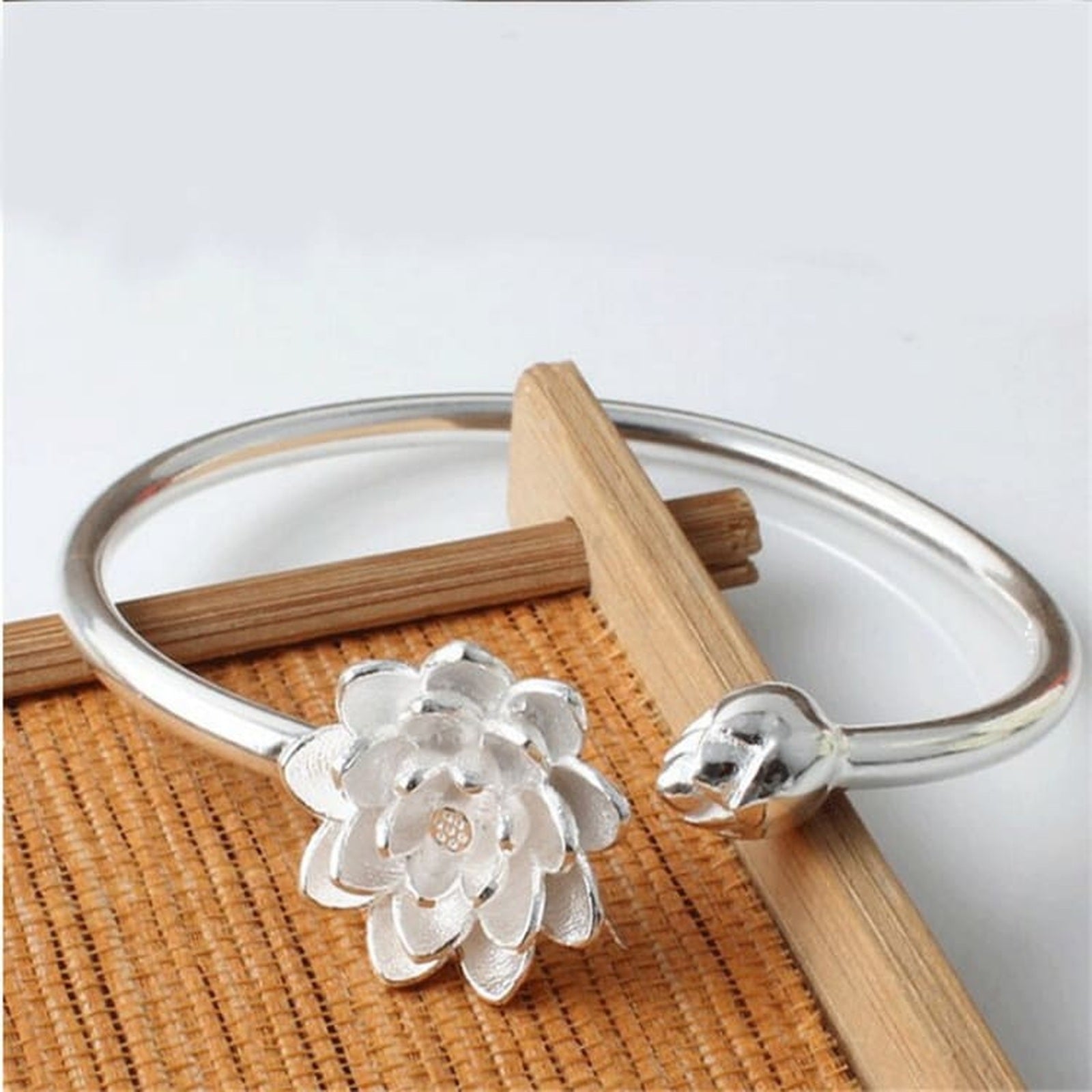 Détail du bracelet lotus argenté sur support en bambou Image