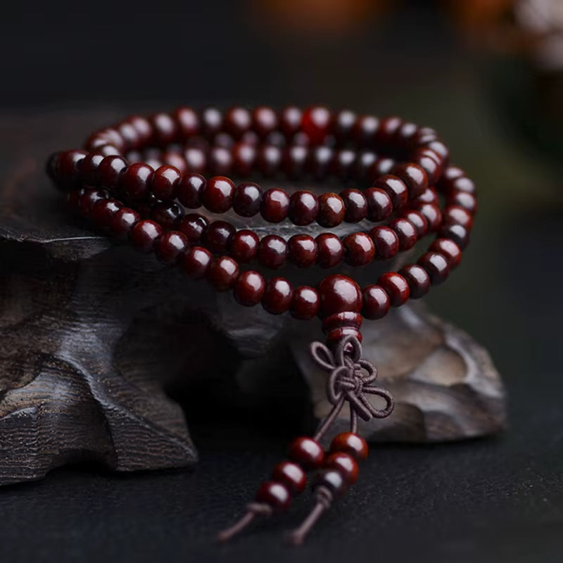 Bracelet Mala Rouge en Bois de Santal sur fond sombre