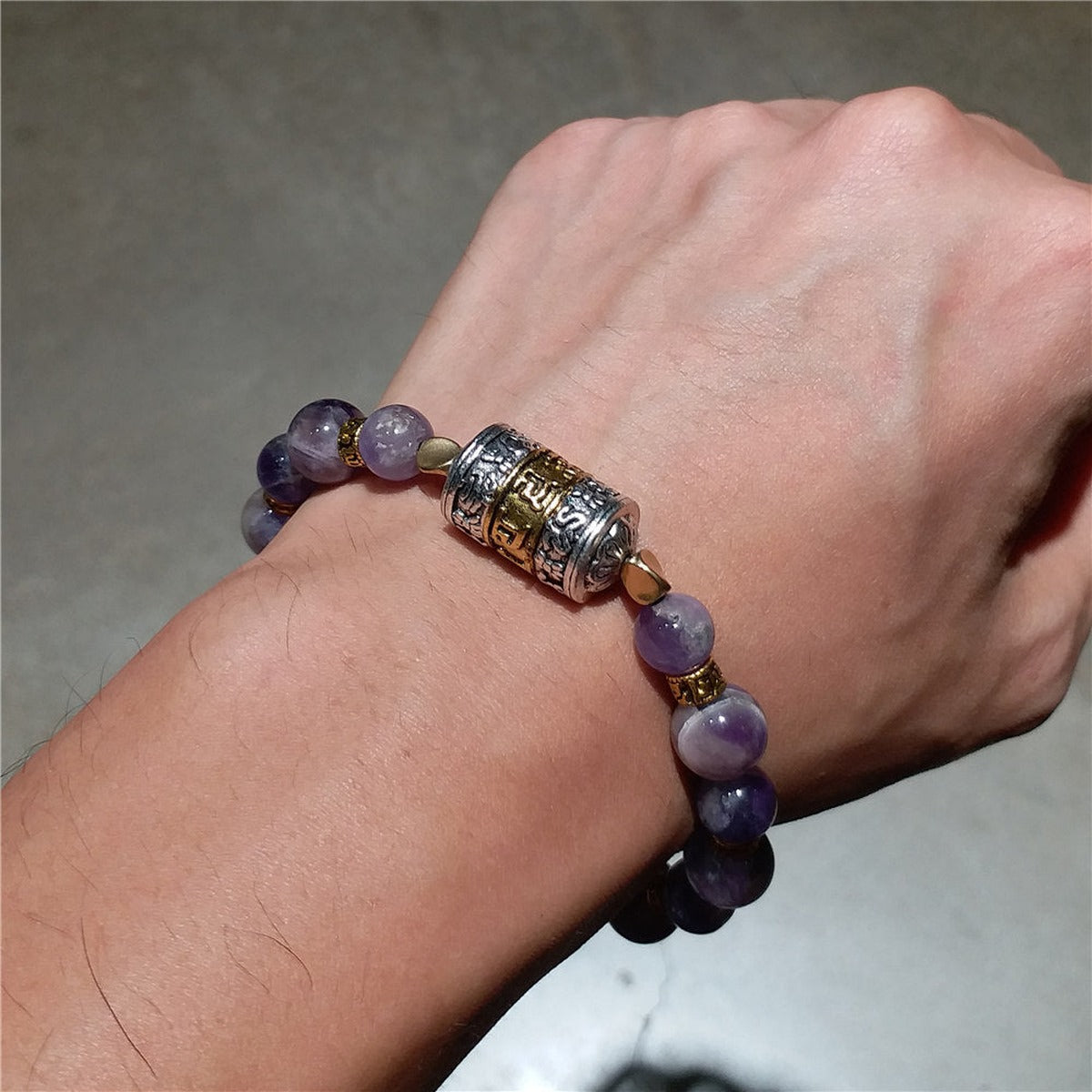Bracelet tibétain bouddhiste porté au poignet, perles d'améthyste et mantra Om Mani Padme Hum