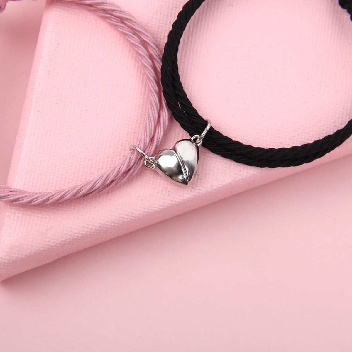Bracelets de couple rose et noir avec les deux moitiés de cœur réunies