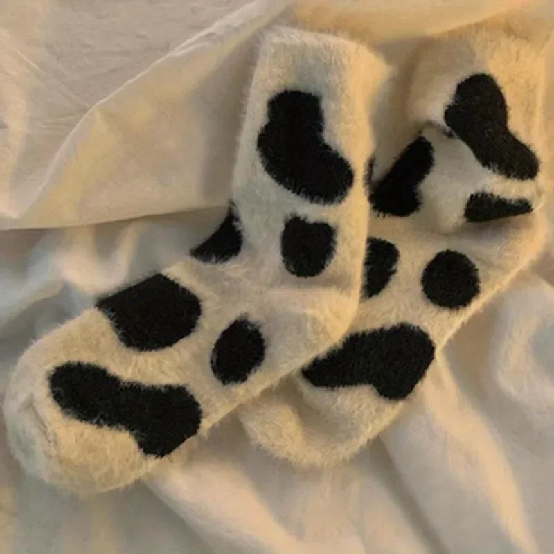 Chaussettes piloulou mignonnes avec imprimés de vaches sur un lit