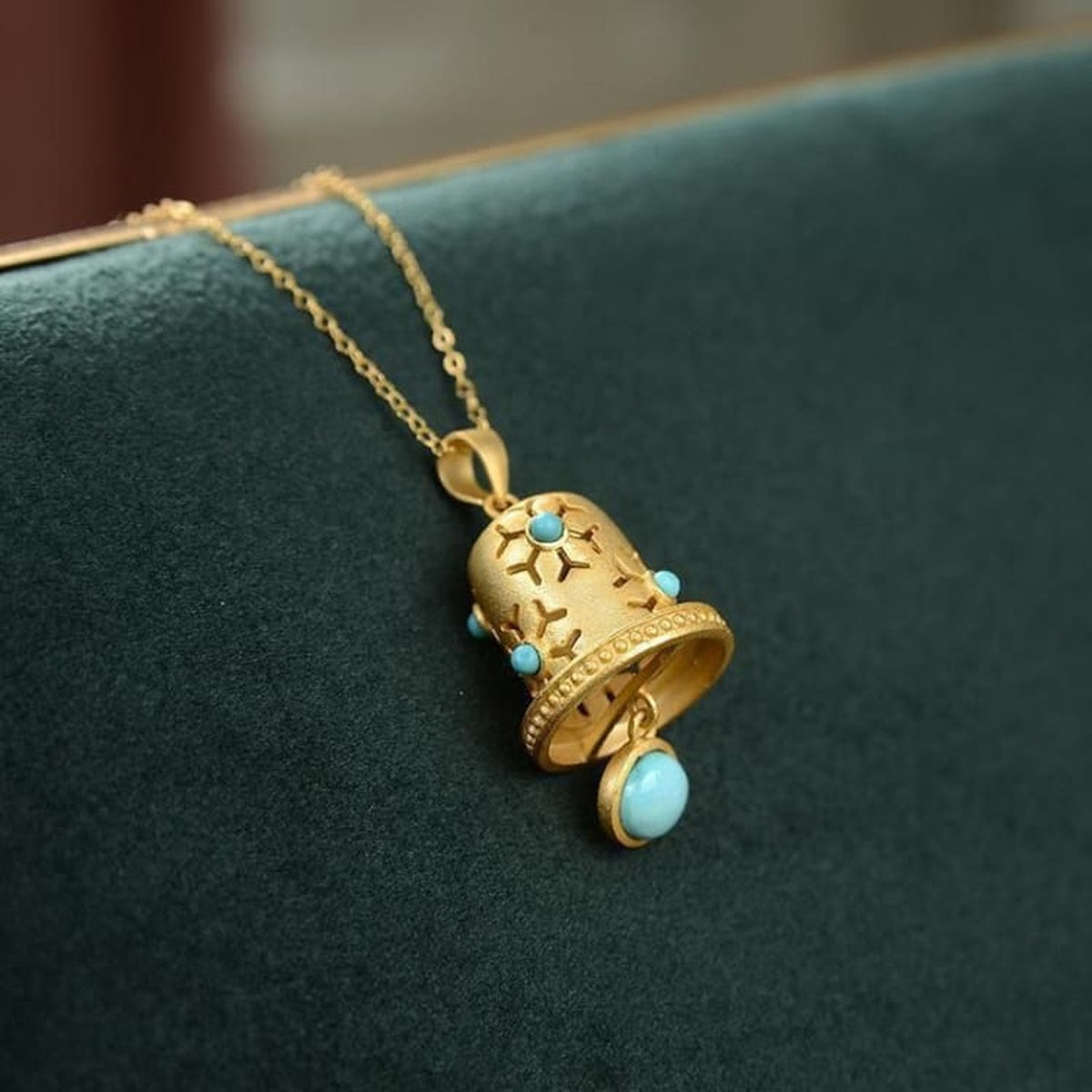 Collier à pendentif cloche dorée ajourée, vue inclinée
