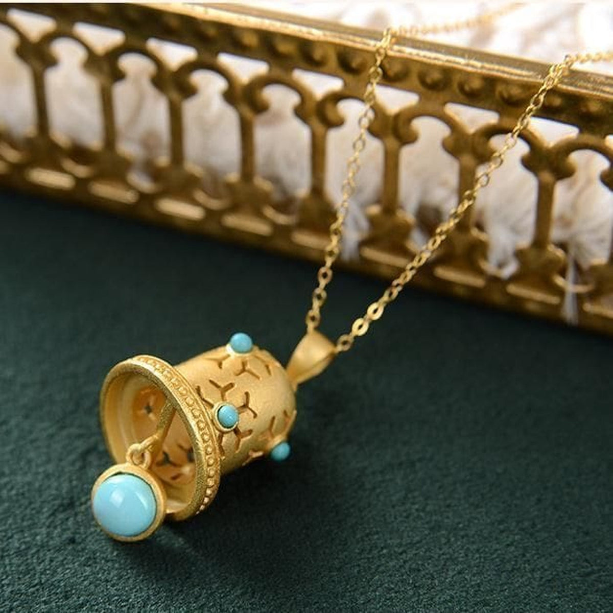 Vue sous le pendentif cloche dorée et son cabochon suspendu