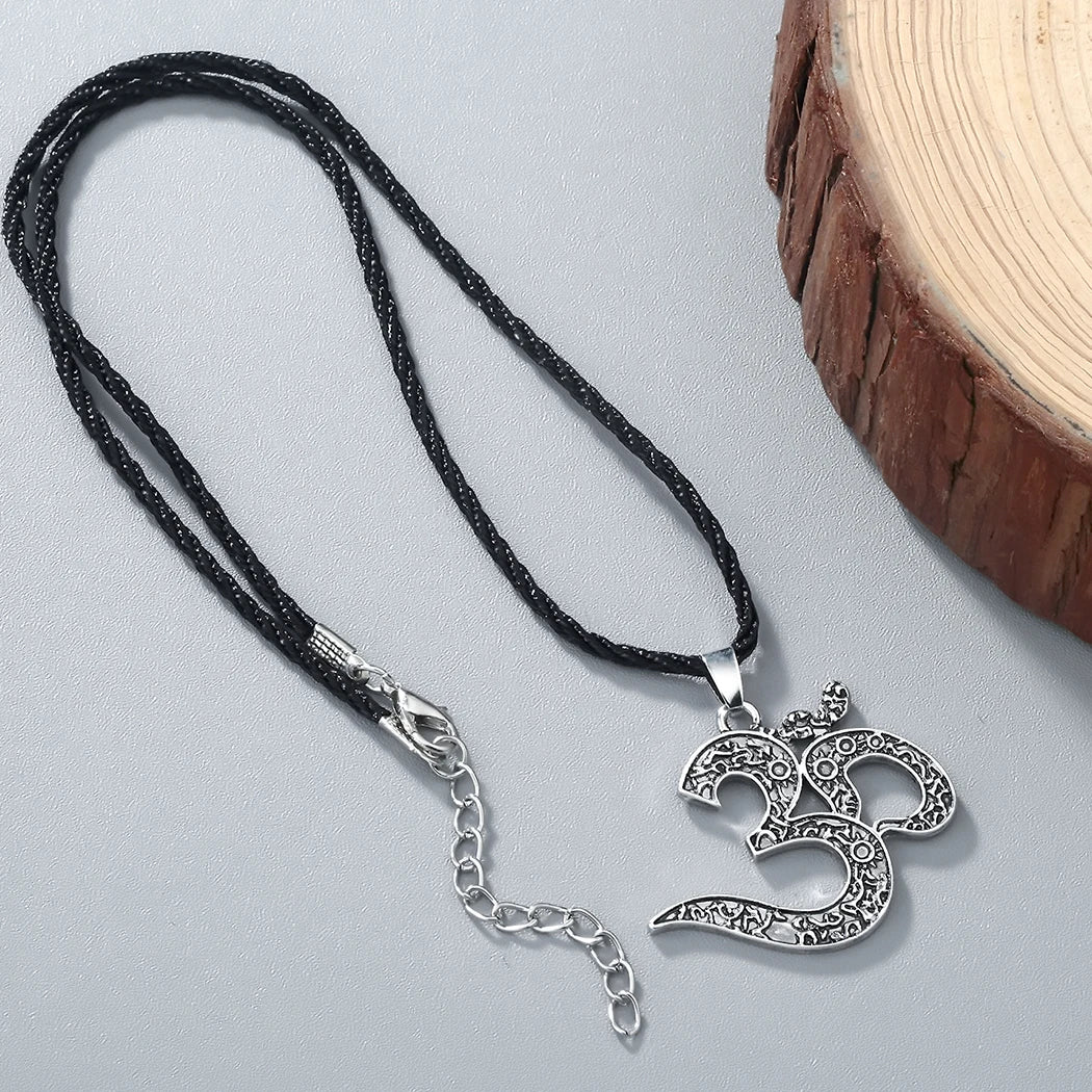 Collier Ohm de style vintage en cuivre sur fond gris avec du bois à droite