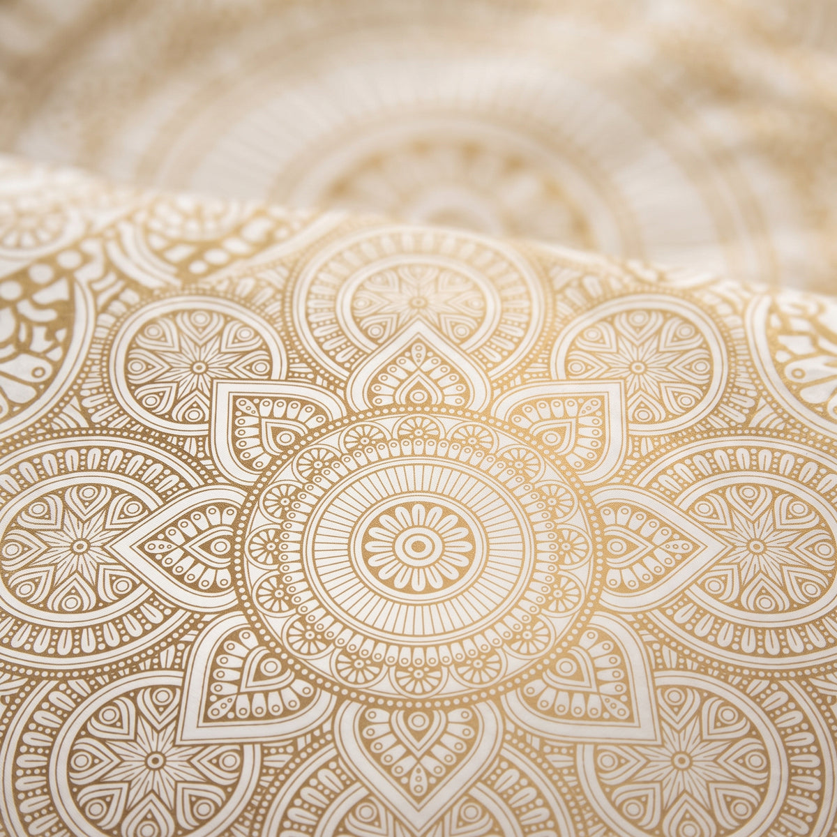 Gros plan sur le motif mandala dore de la housse de couette zen