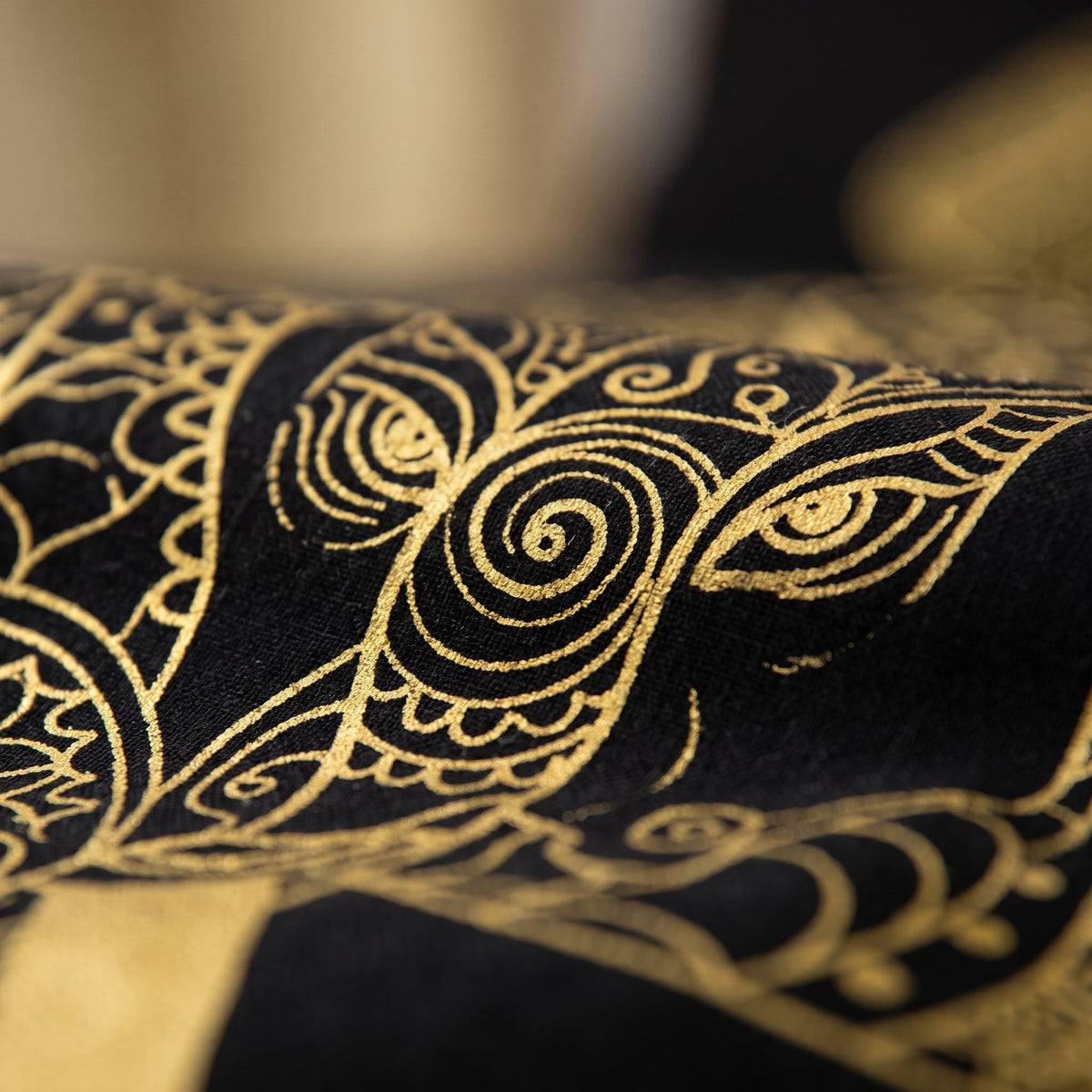 Gros plan sur le motif elephant dore et ses volutes de la housse de couette noire