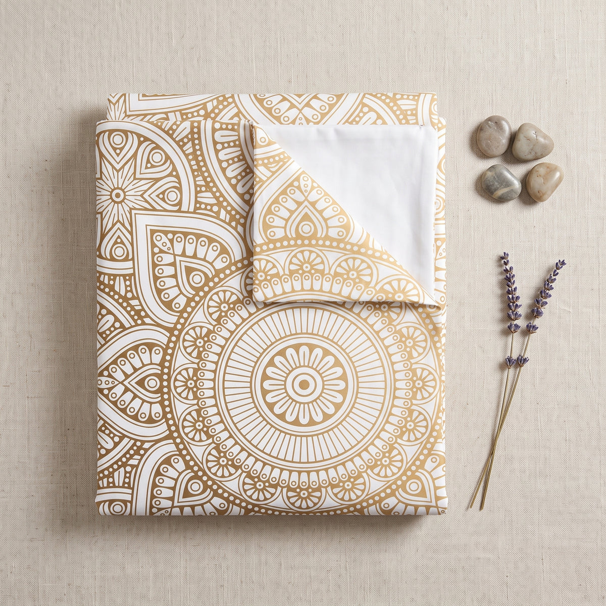Housse de couette mandala pliee a plat sur fond lin avec galets et lavande