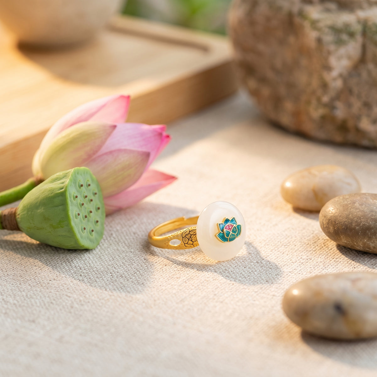 Bague lotus jade posée sur lin avec une fleur de lotus