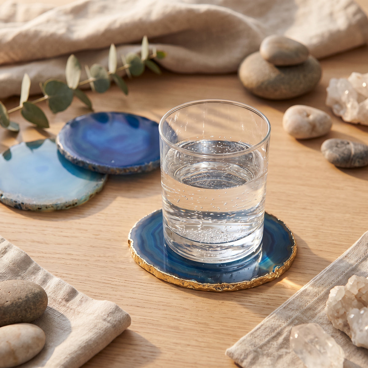 Verre d'eau posé sur un dessous de verre en agate bleue sur une table zen