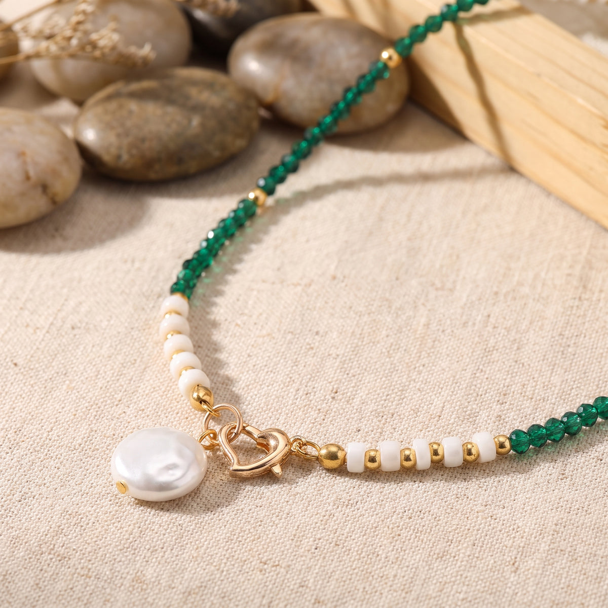 Détail du collier perle baroque, fermoir coeur doré