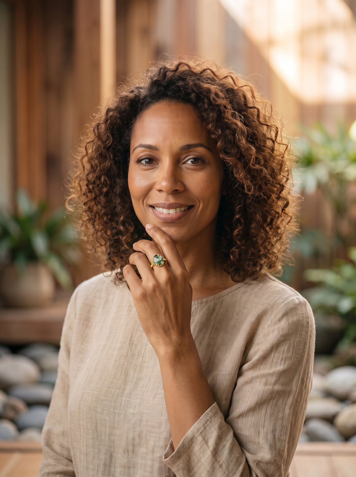 Femme souriante portant la bague agate mousse dorée
