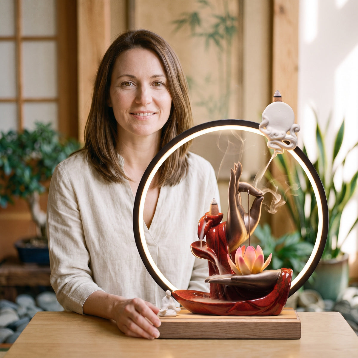 Femme souriante devant le porte-encens à reflux Karana Mudrā allumé, échelle réelle de l'objet