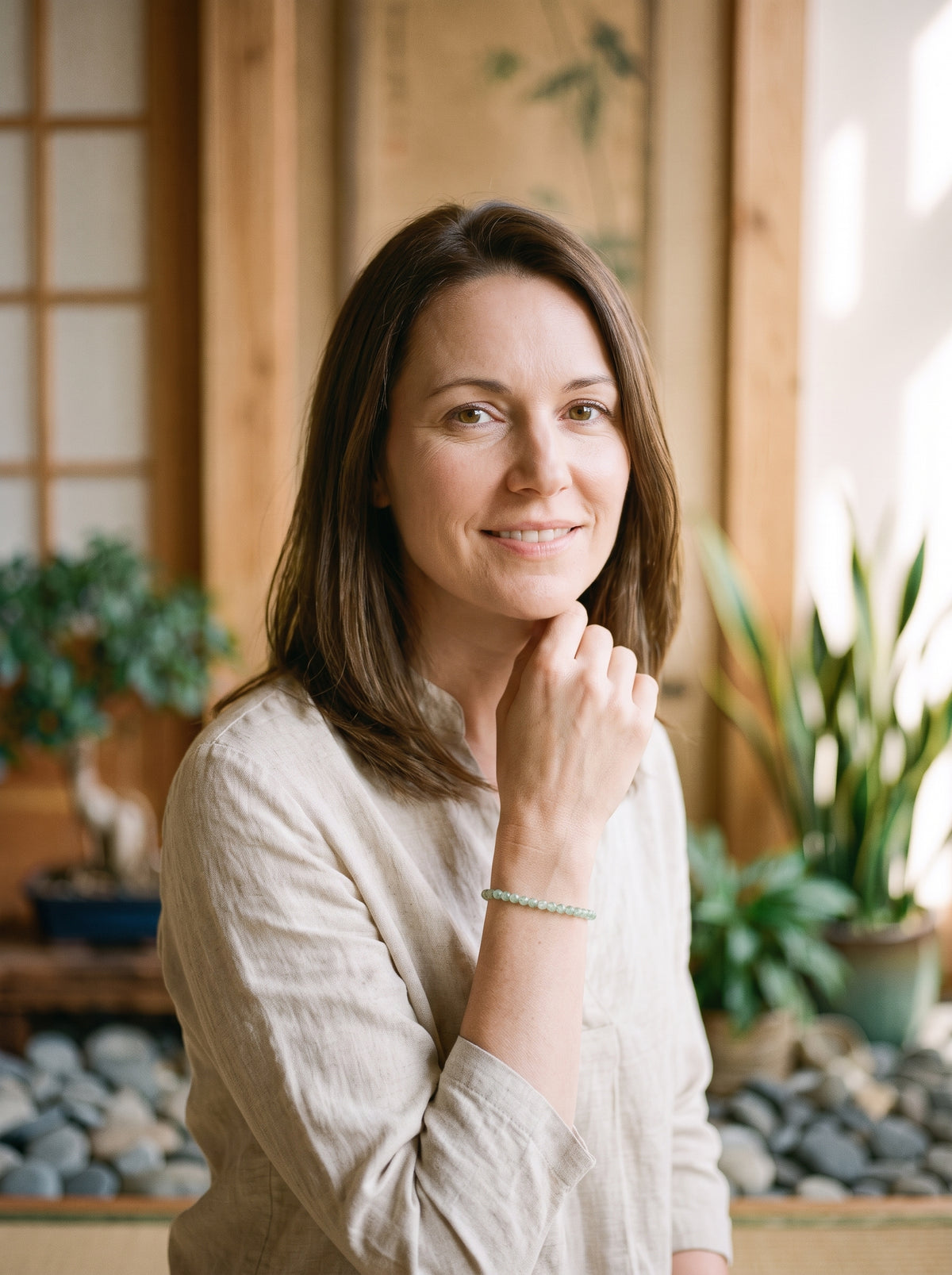 Femme souriante portant le bracelet fin en jade vert au poignet