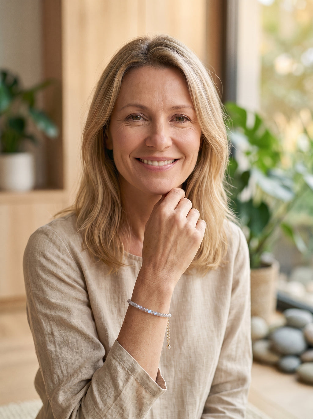 Femme souriante portant le bracelet fin en pierre de lune