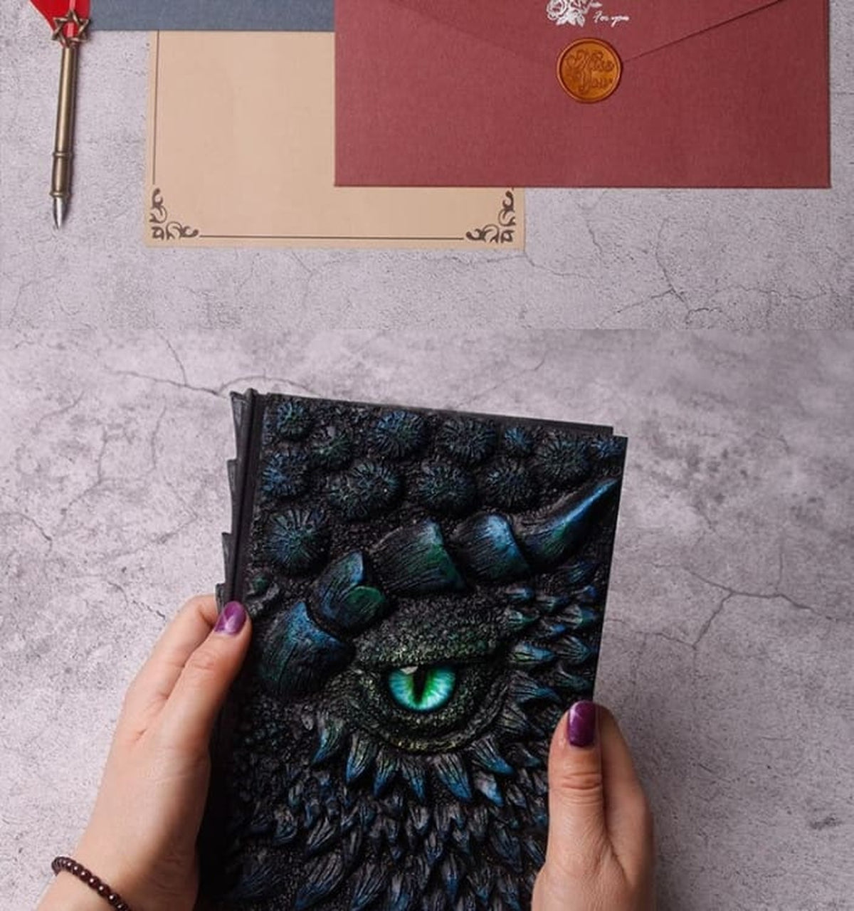 Carnet de notes Dragon Œil de Dragon Bleu tenu entre les mains sur un bureau