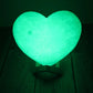 Lampe d'ambiance LED en forme de coeur à couleur variable posée sur une table en bois