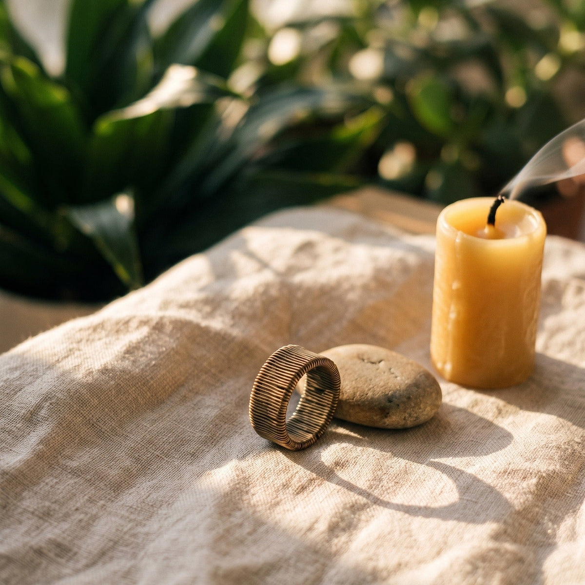 Bague en cuivre fil spiralé posée sur lin, ambiance zen et pierres
