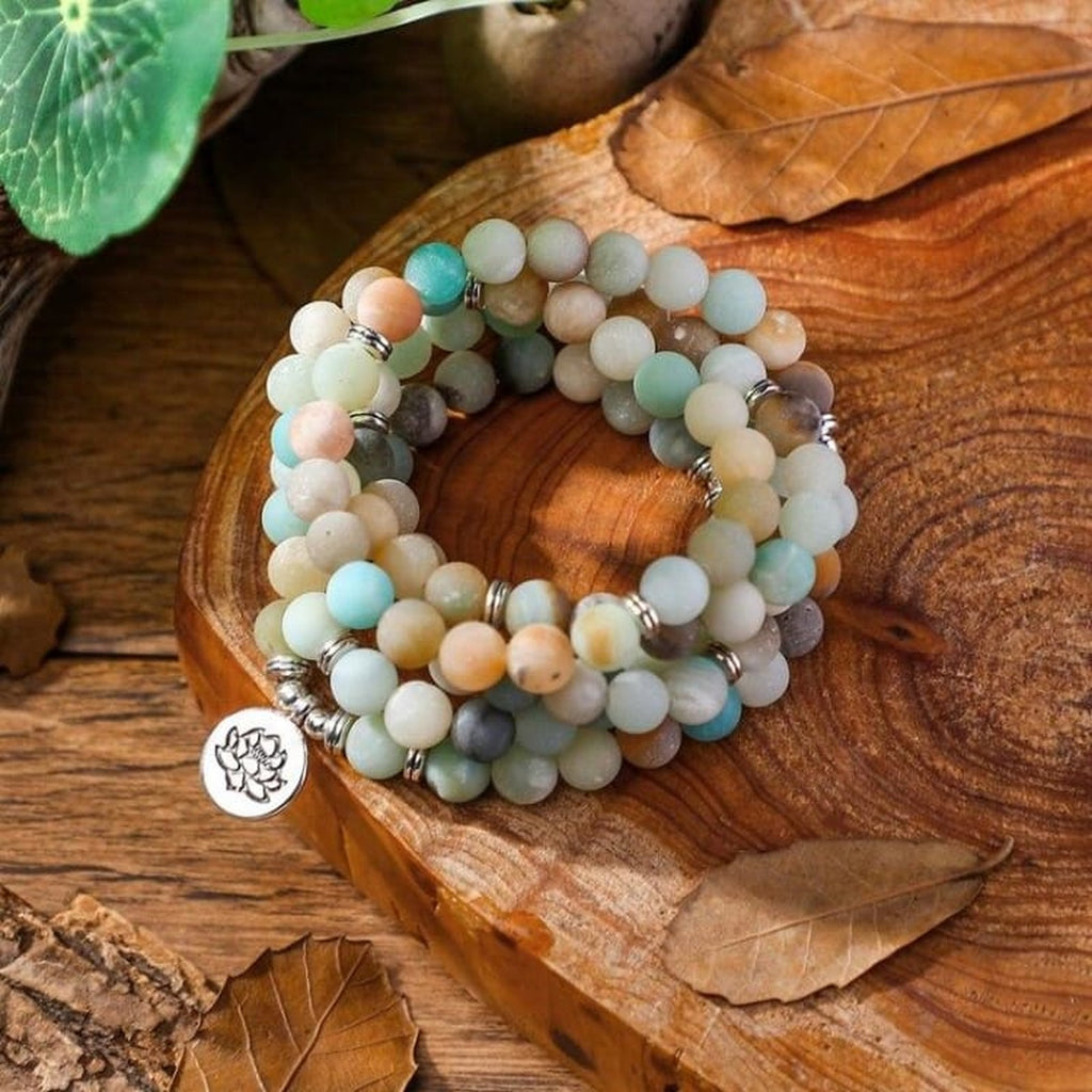 Mâla en Amazonite avec pendentif Lotus posé sur du bois