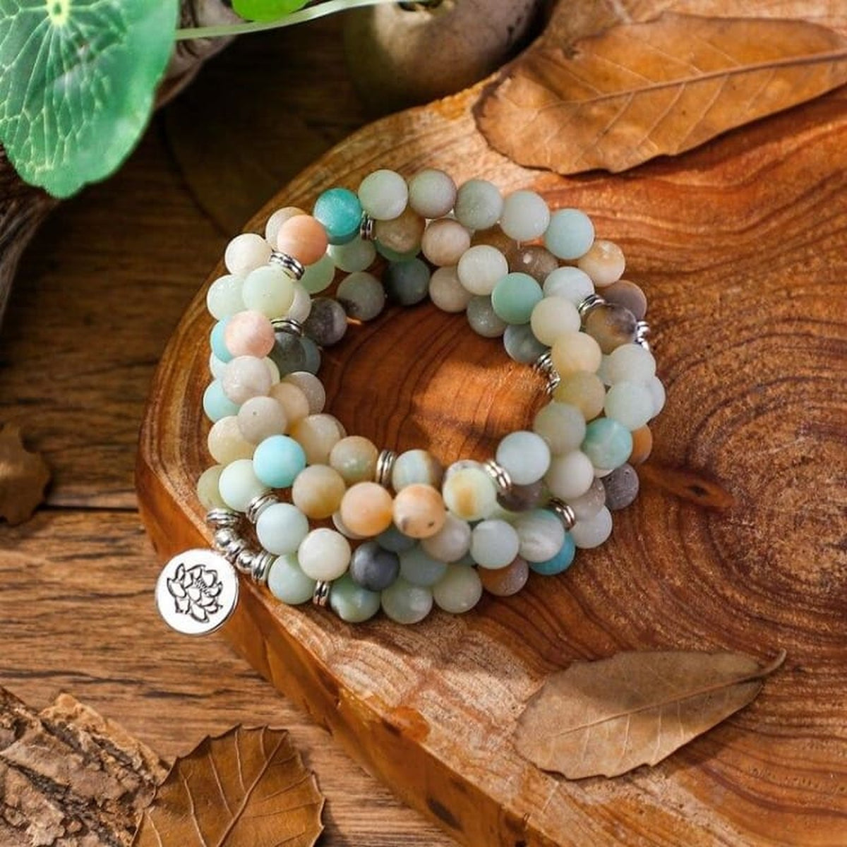 Mâla en Amazonite avec pendentif Lotus posé sur du bois