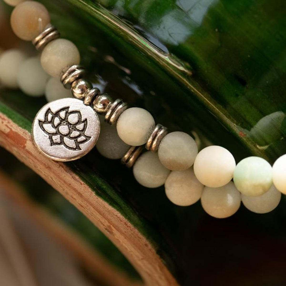 Détail des perles multicolores et du pendentif Lotus argenté