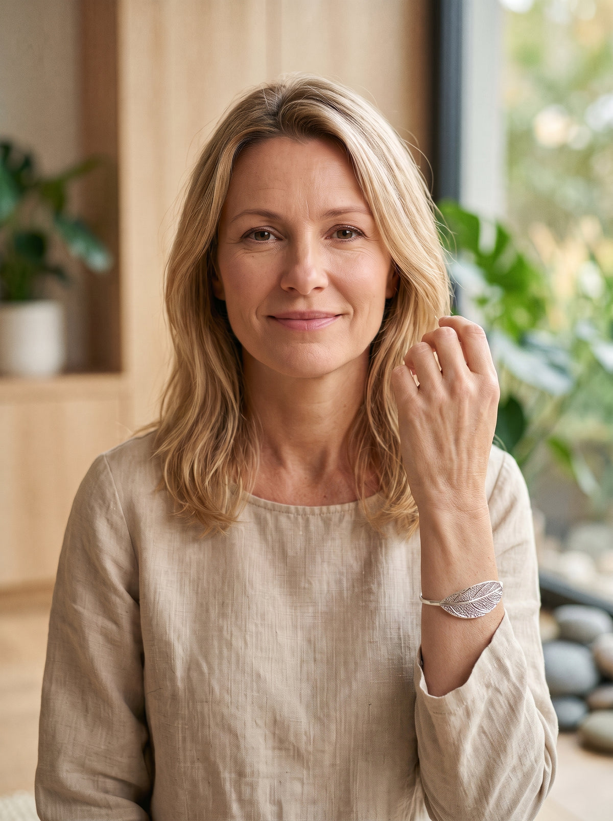 Bracelet Jonc Feuille Argenté porté par un modèle souriant, visage visible, décor zen