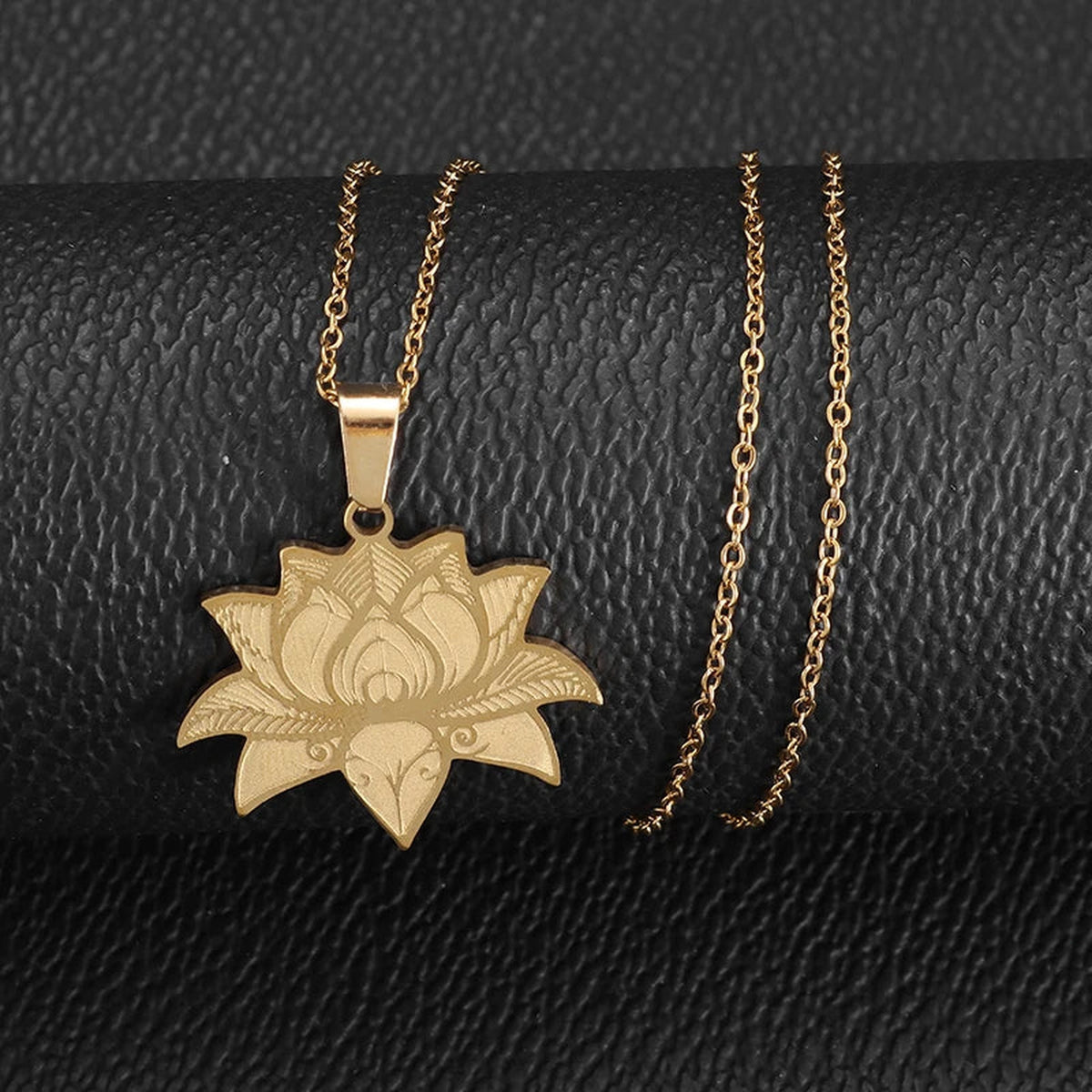 Pendentif fleur de lotus doré présenté avec sa chaîne sur fond noir
