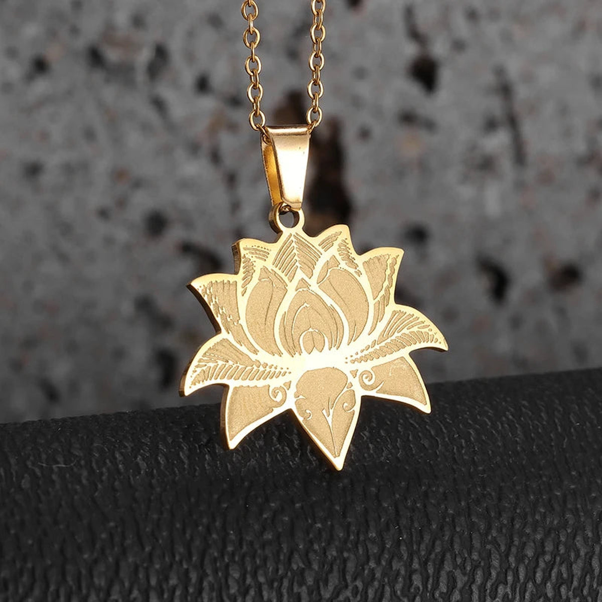 Détail des pétales et lignes gravées du pendentif lotus doré