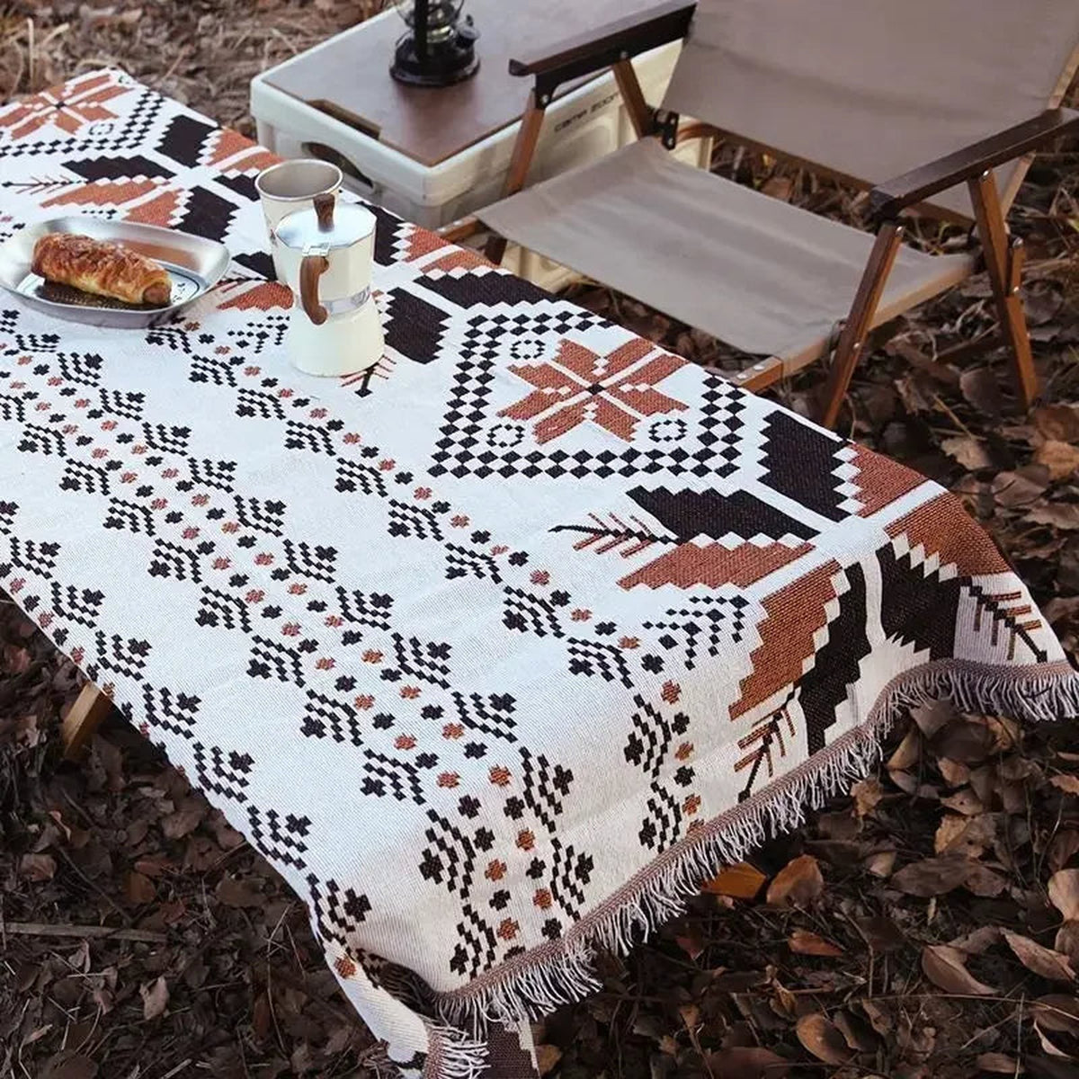 Plaid géométrique utilisé comme nappe sur une table extérieure