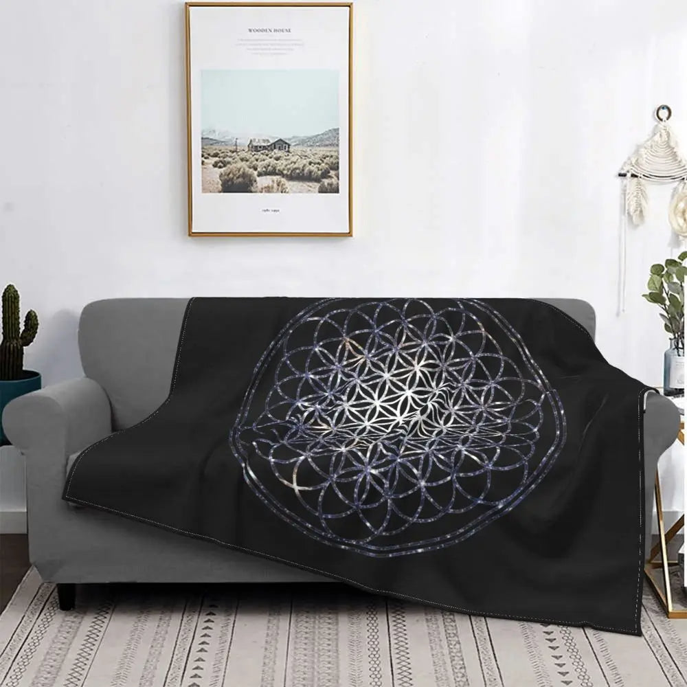 Plaid noir avec mandalas sur un canapé sur fond blanc avec un tableau