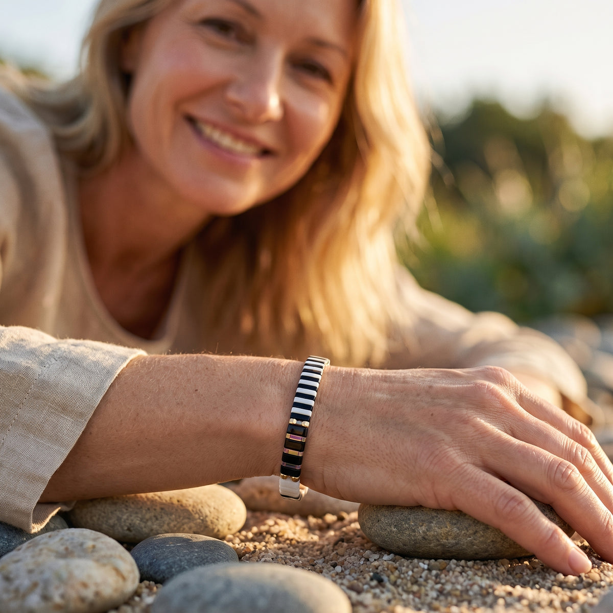 Femme portant un bracelet en perles de verre japonaises au poignet, souriante, nature