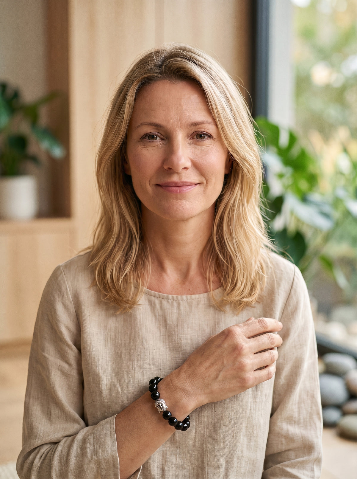 Femme souriante portant le bracelet Bouddha en Obsidienne