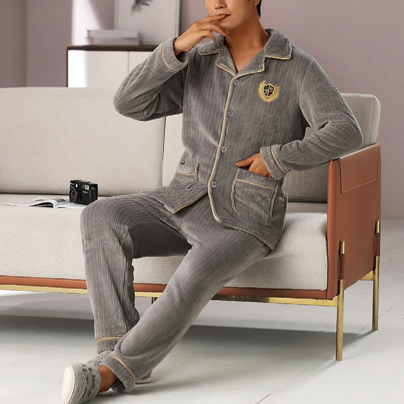 Pyjama polaire deux pièces à col rabattu pour homme sur un homme sur fond gris assis sur un canapé gris