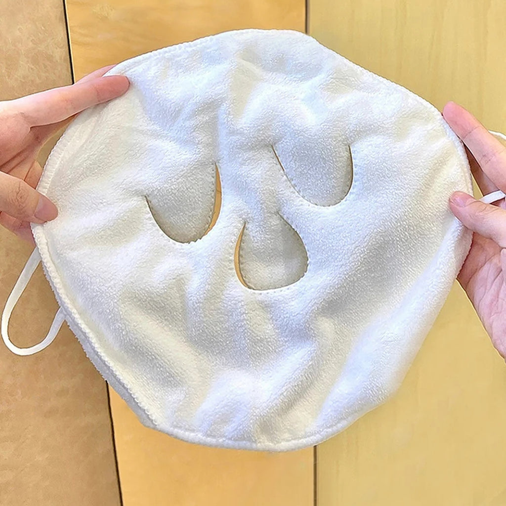 Serviette faciale blanche tenue entre deux mains montrant ses ouvertures et boucles