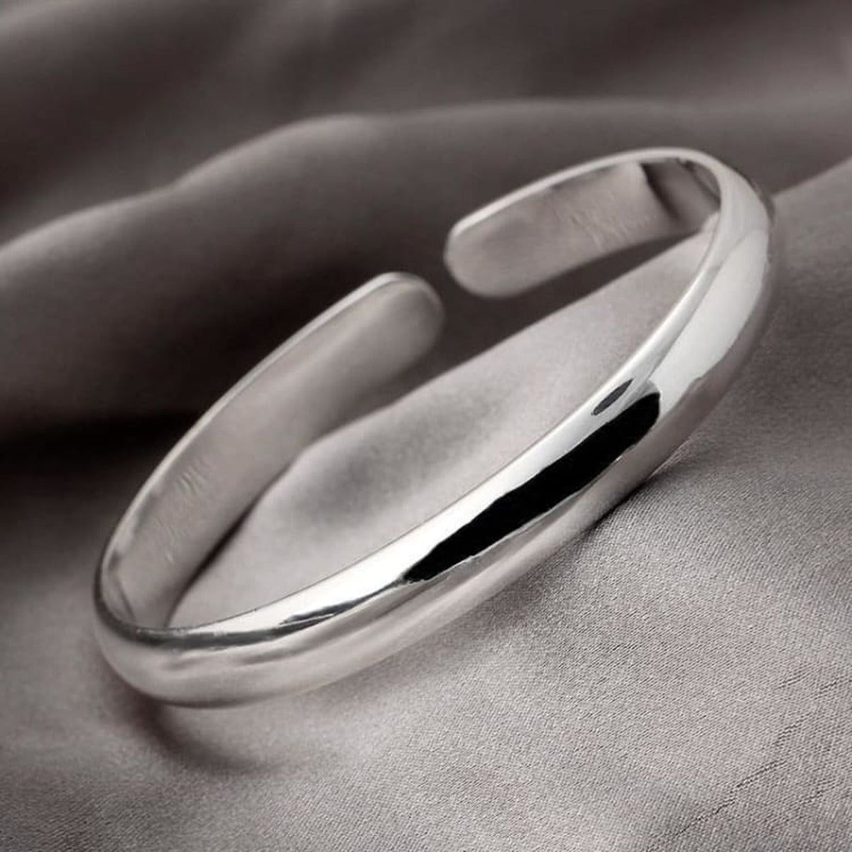Bracelet jonc en acier inoxydable argenté - détail du poli sur tissu gris